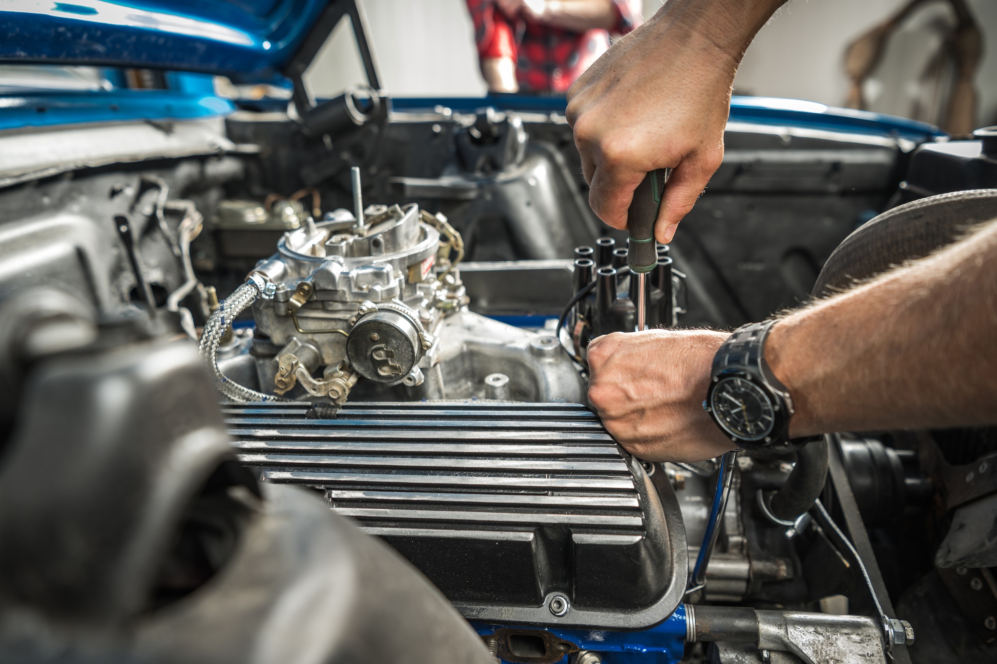 Car Enthusiast Repairs Engine in Automotive Workshop During Daytime