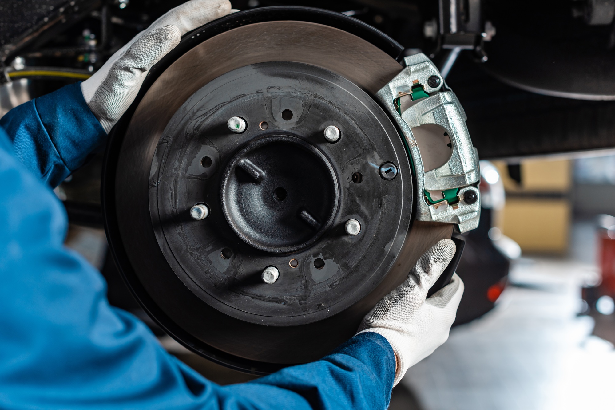 cropped view of mechanic adjusting assembled disc brakes with brake caliper